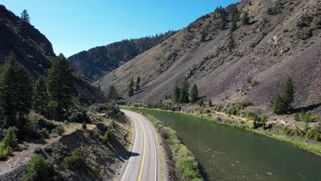 Vista-Aérea-Del-Río-Snake-En-Idaho-Con-Una-Carretera-Vacía-De-Dos-Carriles-Junto-Al-Agua