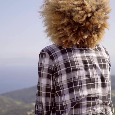 mujer disfrutando de la vista del océano y las montañas