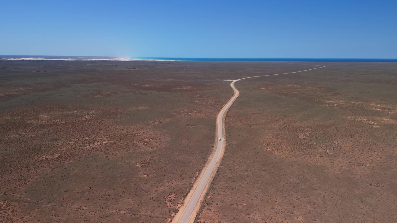 Vista aérea de un coche conduciendo por el Nullarbor hacia los acantilados