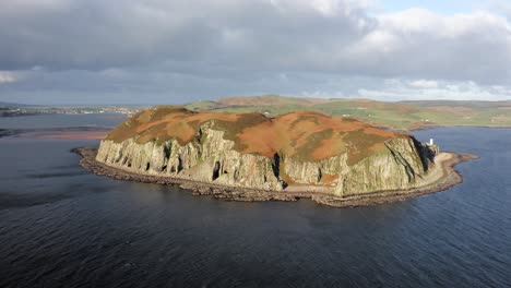 aerial - epic shot of sunbathed island davaar, kintyre, scotland, reverse rising