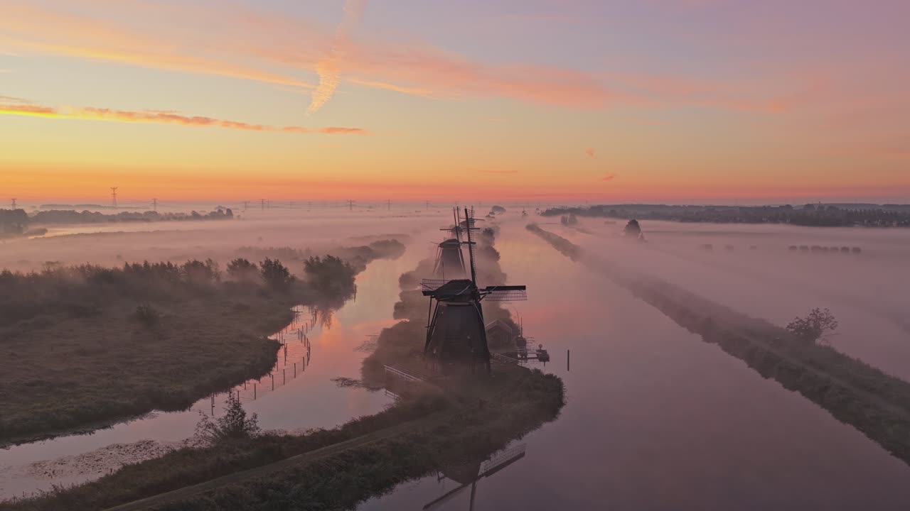 Scenografica campagna olandese con i mulini storici di Kinderdijk all'alba nella nebbia