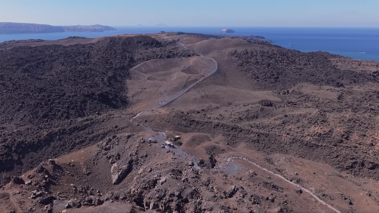 Vista panoramica della principale area vulcanica di Santorini, che mostra un terreno aspro, formazioni di caldera e il profondo Mar Egeo blu