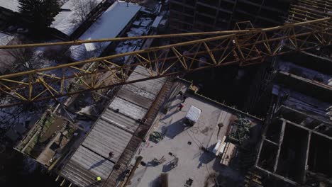 overview of crane in a construction site with workers walking