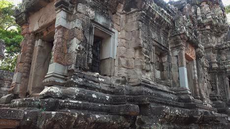 close exterior pan shot of temple built by stone blocks in the ancient times near angkor wat