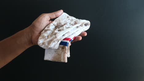 calcetín sucio en la mano