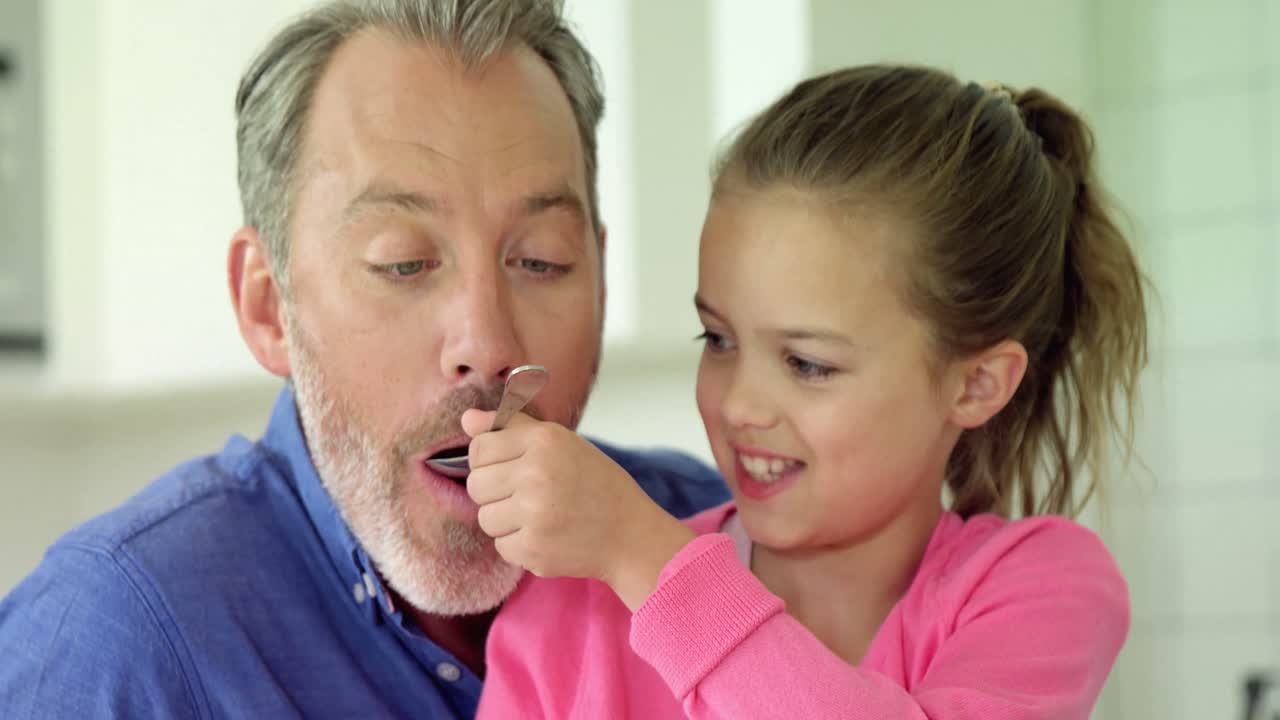 Daughter feeding her father with spoon