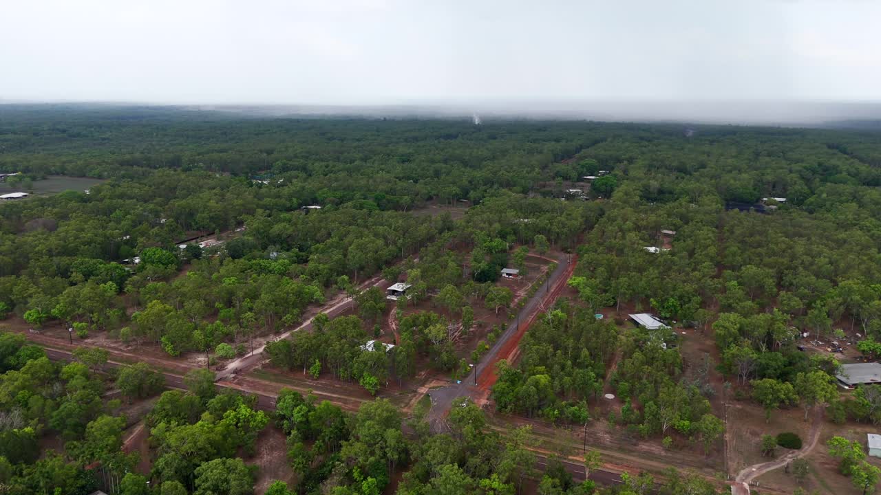 Aerial drone of rural farmland in Darwin, NT, with rain clouds in the background over agricultural land, dense forested plots