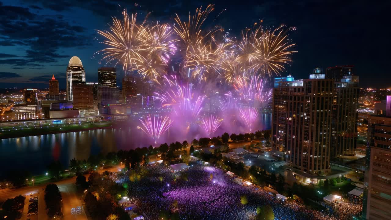 A Stunning Nighttime Display of Colorful Fireworks Illuminating the City Skyline, Creating an Atmosphere of Joy and Celebration Overlooking the Vibrant Crowd Gathered in the Park by the Water