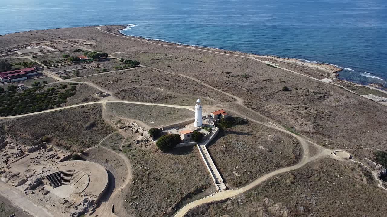 Wide areial pull back over the Odeom Paphos Lighthouse and amphitheater.
