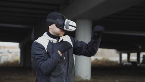 man wearing vr headset boxing in urban underpass