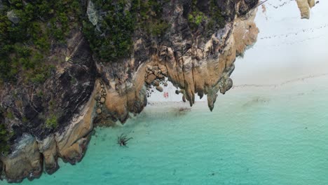 una vista de dron de 4k mirando hacia abajo a una pareja acostada una al lado de la otra en la playa de whitehaven en la isla de whitsundays, en los whitsunday