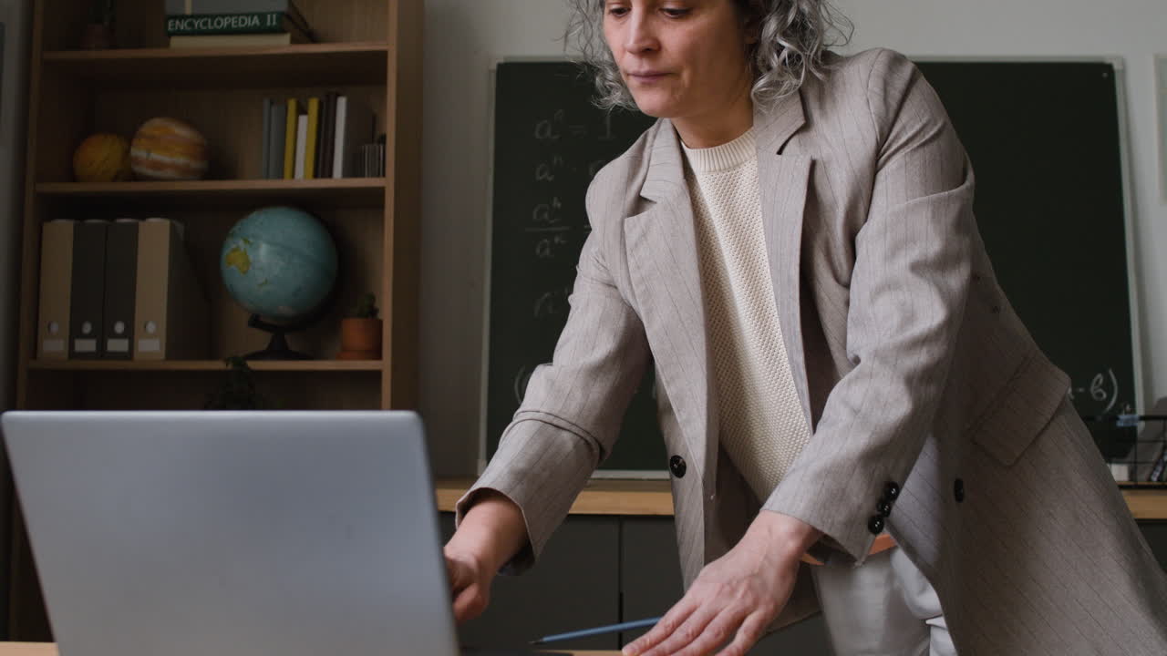 Teacher using a laptop in a classroom