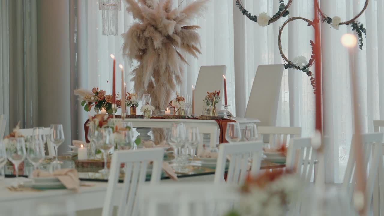 refined white wedding tables with candles and boho floral decor