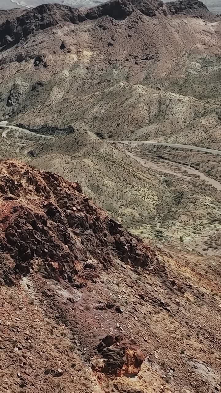 Birds eye view of rocky terrain and winding road in USA's desert region