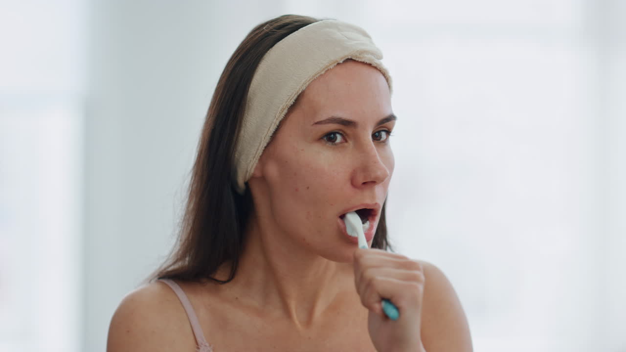 mujer relajada limpiando los dientes por la mañana en el interior de primer plano. cuidado dental cotidiano