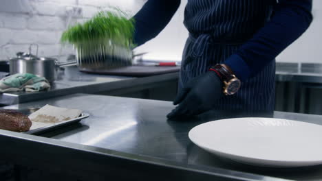 the male chef makes the composition of the dish for serving the cook prepares a dish with fish