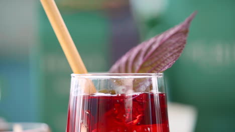 slow motion of falling ice cube into a cup of red herbal tea