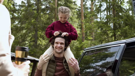 men talking while kid plays with the hair of one of them