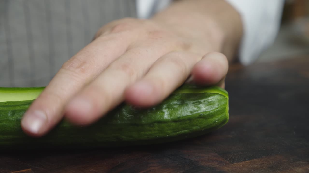 cortar pepino con cuchillo de cocina por la mitad