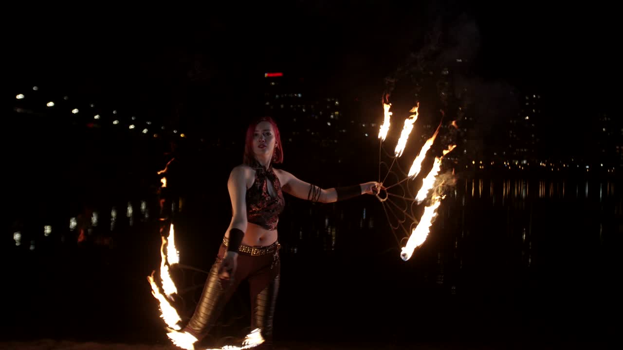 artista creando un círculo de fuego girando ventiladores al anochecer