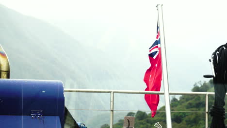 new zealand red ensign flying on boat in milford sound