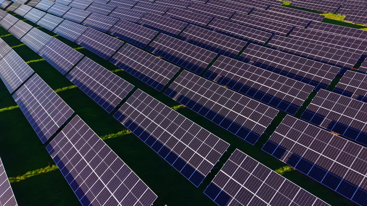 Vasti campi di pannelli solari scintillano sotto il sole splendente in un paesaggio verde, sfruttando l'energia rinnovabile per un futuro sostenibile.
