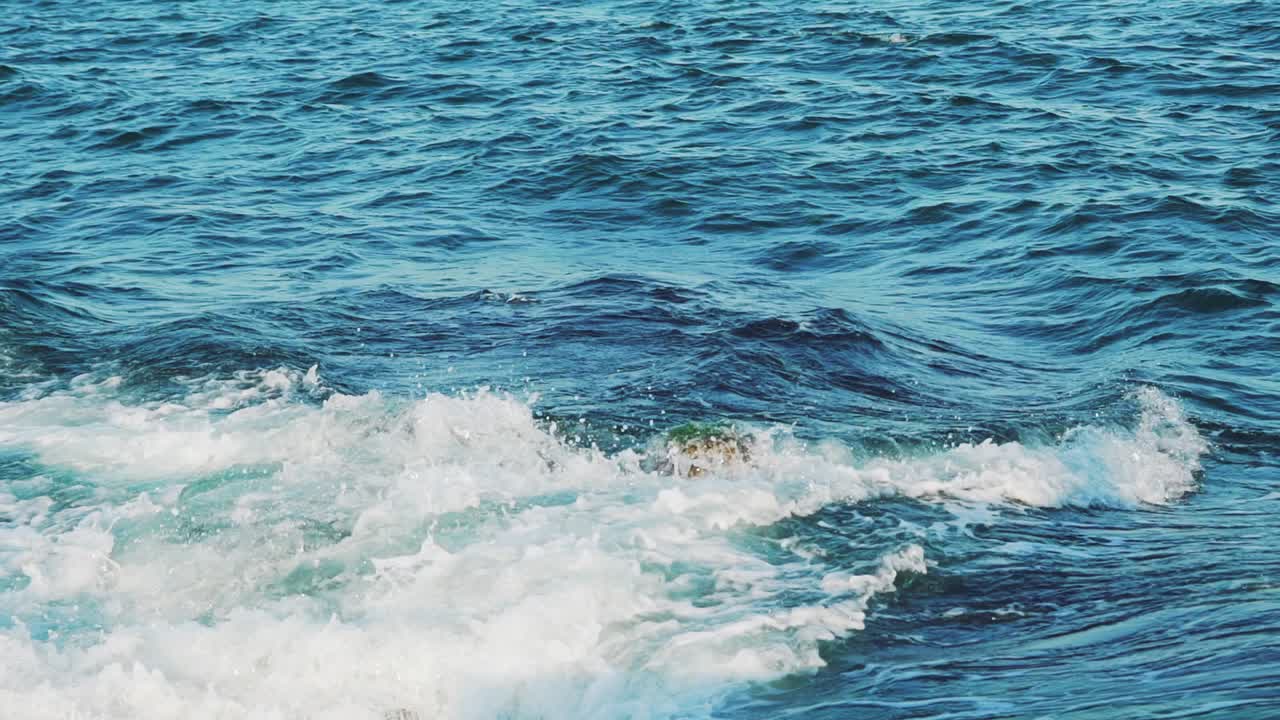 Sea. Splashes of the wave scatter from the impact of the breakwater. Slow motion.