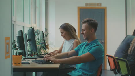smiling guy telling joke at coworking. happy people laughing in office.
