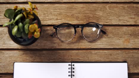 olla, café negro, gafas, organizador y bolígrafo en una mesa de madera 4k