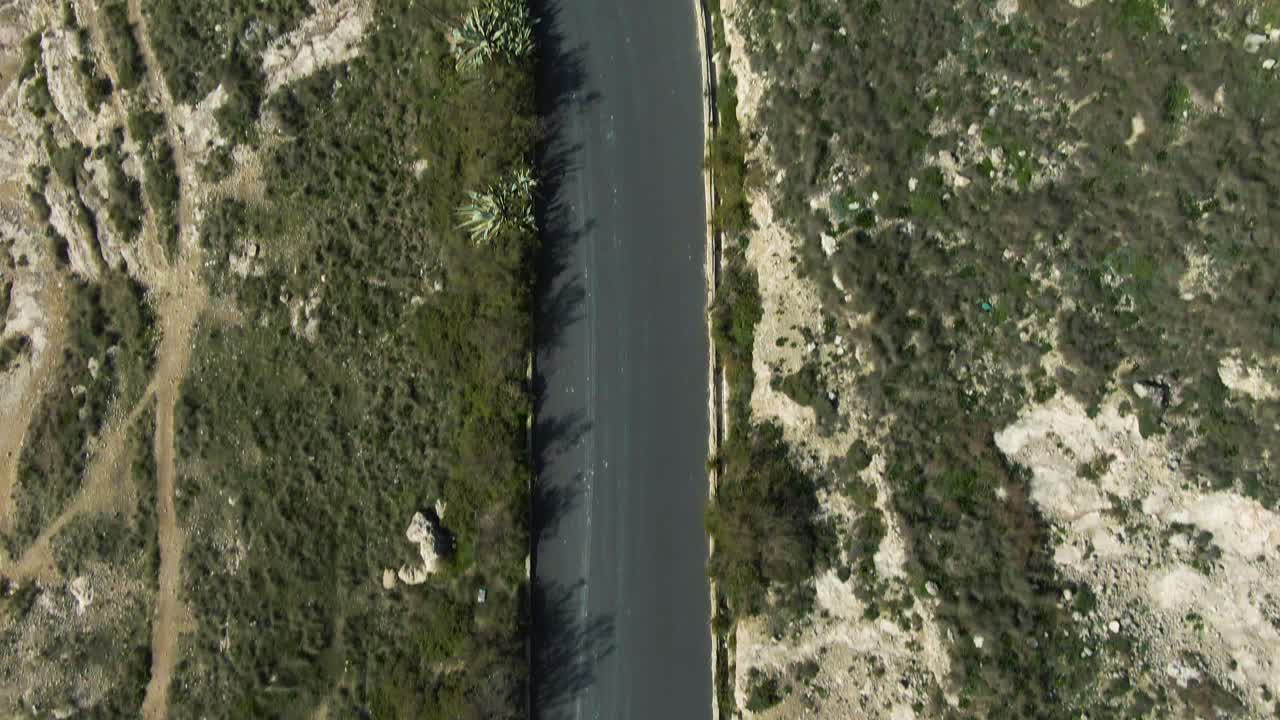 Auto da corsa in pista che si dirige verso la svolta a U con tempo sereno - Ripresa aerea.