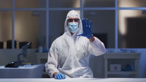 caucasian male medical worker wearing protective clothing and mask using virtual digital interface i