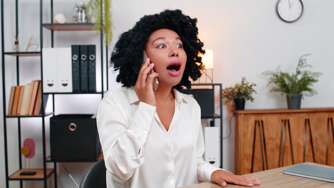 African american businesswoman argues loudly on smartphone upset by dispute during tense phone call