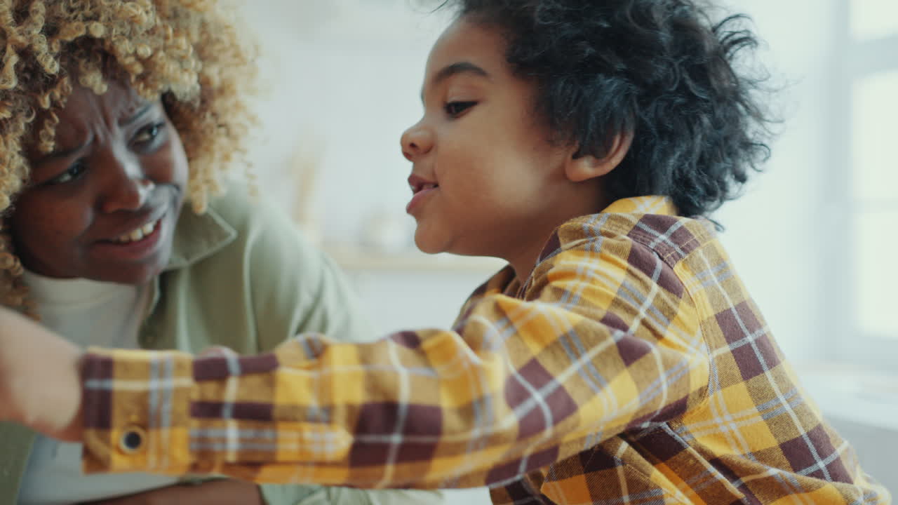 African American Kid Discussing Something on Laptop Screen with Mom at Home
