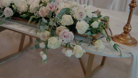 elegant floral centerpiece with roses and greenery on a decorated table indoors