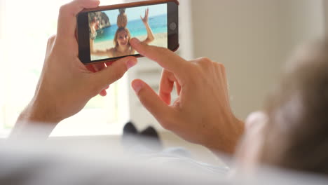 a woman zooming into photos on her mobile phone