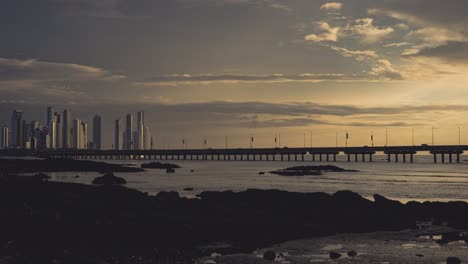 dramatic sunset city skyline with bridge and ocean