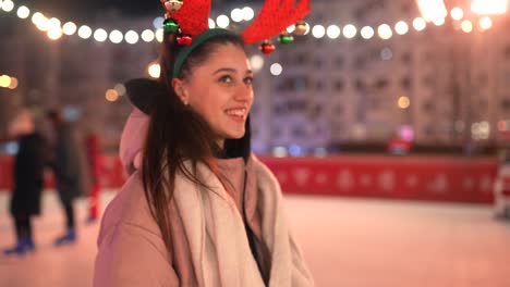 mujer patinando sobre hielo por la noche con cuernos de reno