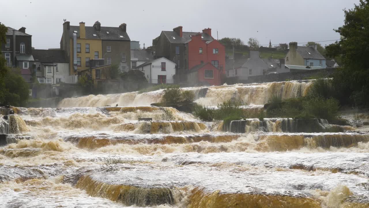 Air terjun sungai yang tenang di dekat kota berwarna-warni di Ennistymon, pemandangan Irlandia