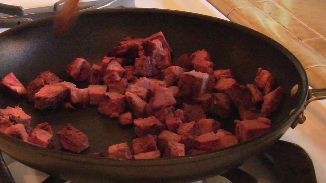 trozos de carne cocinada en una sartén