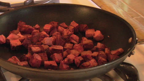 trozos de carne cocinada en una sartén