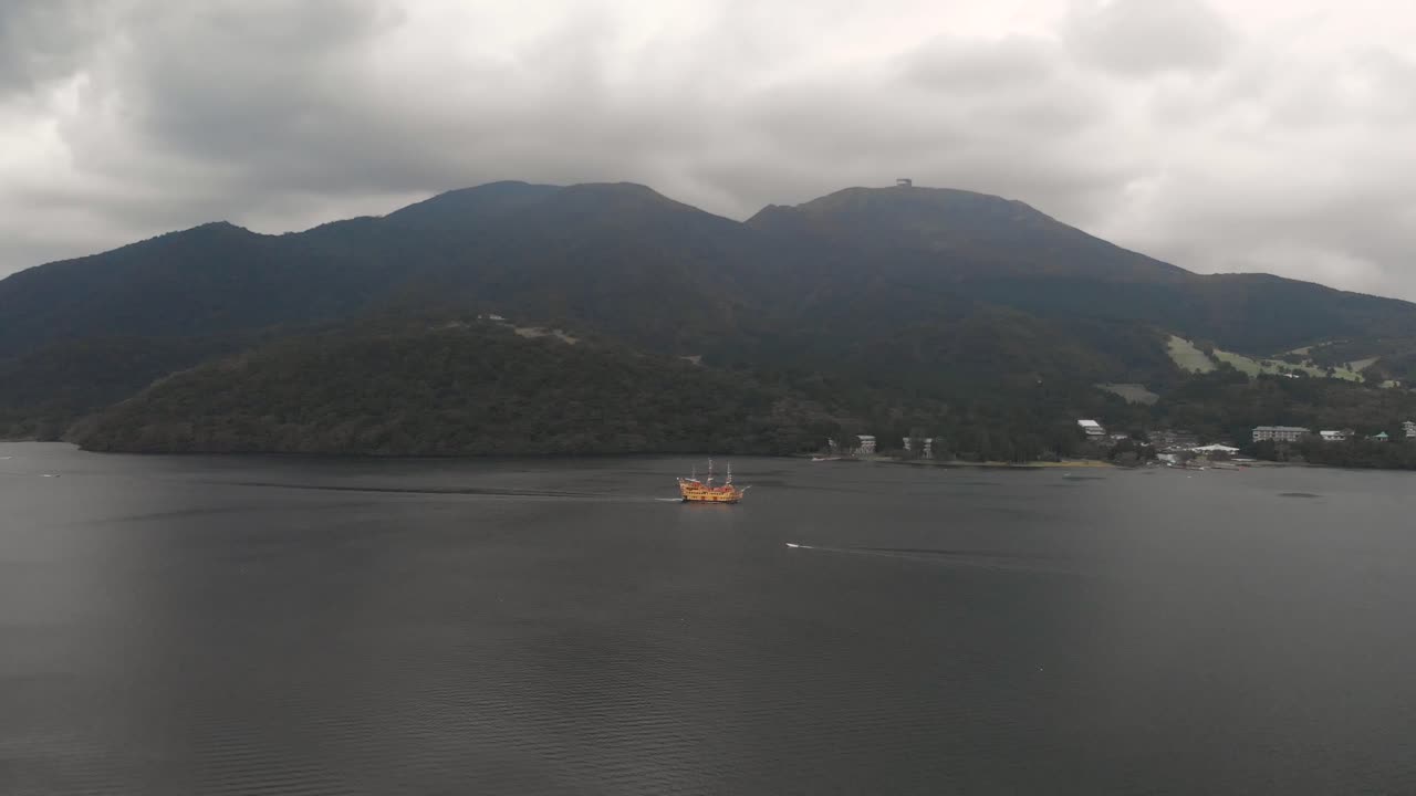 여행자를 수송하는 주황색 해적선과 함께 하코네의 아시 호수 위로 오른쪽 패닝 공중