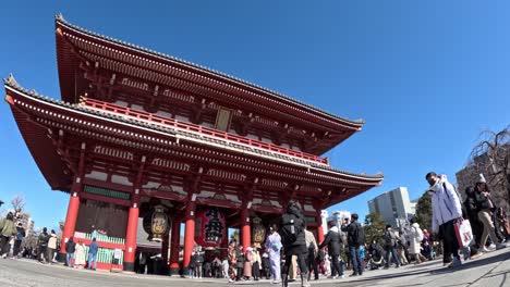 crowds visiting a large traditional red temple