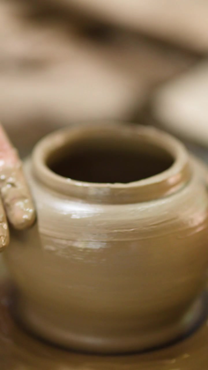 Mani artigiane modellano abilmente un vaso di argilla bagnata su un tornio da vasaio a Nonthaburi