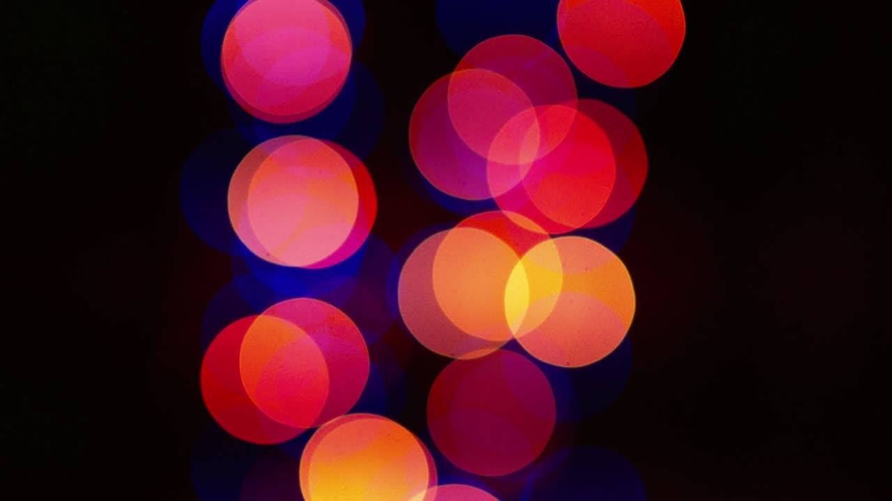 검은색 배경에 다채로운 박이는 보케가 있습니다.