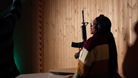 cliente de la galería de tiro usando rifle para golpear objetivos, siendo felicitado