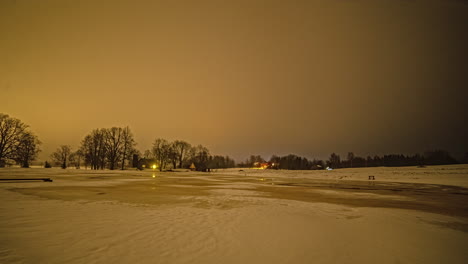 Timelapse-of-cabins-caught-in-winter-storm-and-snow-melting,-with-light-rays-from-house