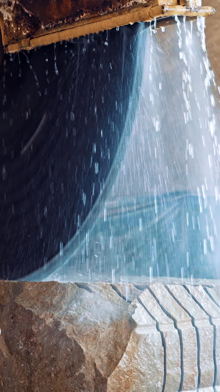 Marble being cooled with water. Marble cooled with water while being cut Vertical video