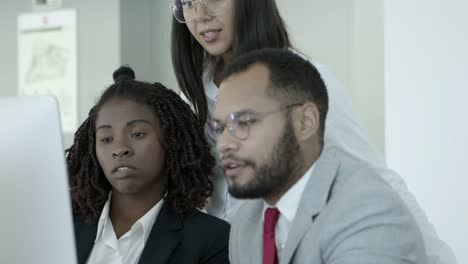 multiethnic coworkers using desktop computer