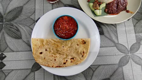 a simple yet flavorful dish featuring soft chapati served with rich sambal sauce. this indian flatbread, made from wheat flour, pairs perfectly with the spicy, tangy condiment.
