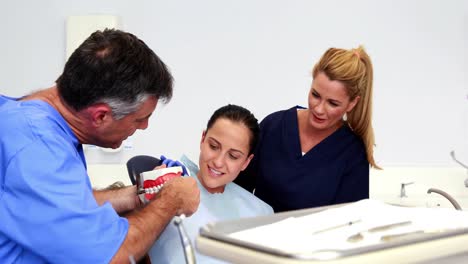 dentist explaining how to brush teeth correctly